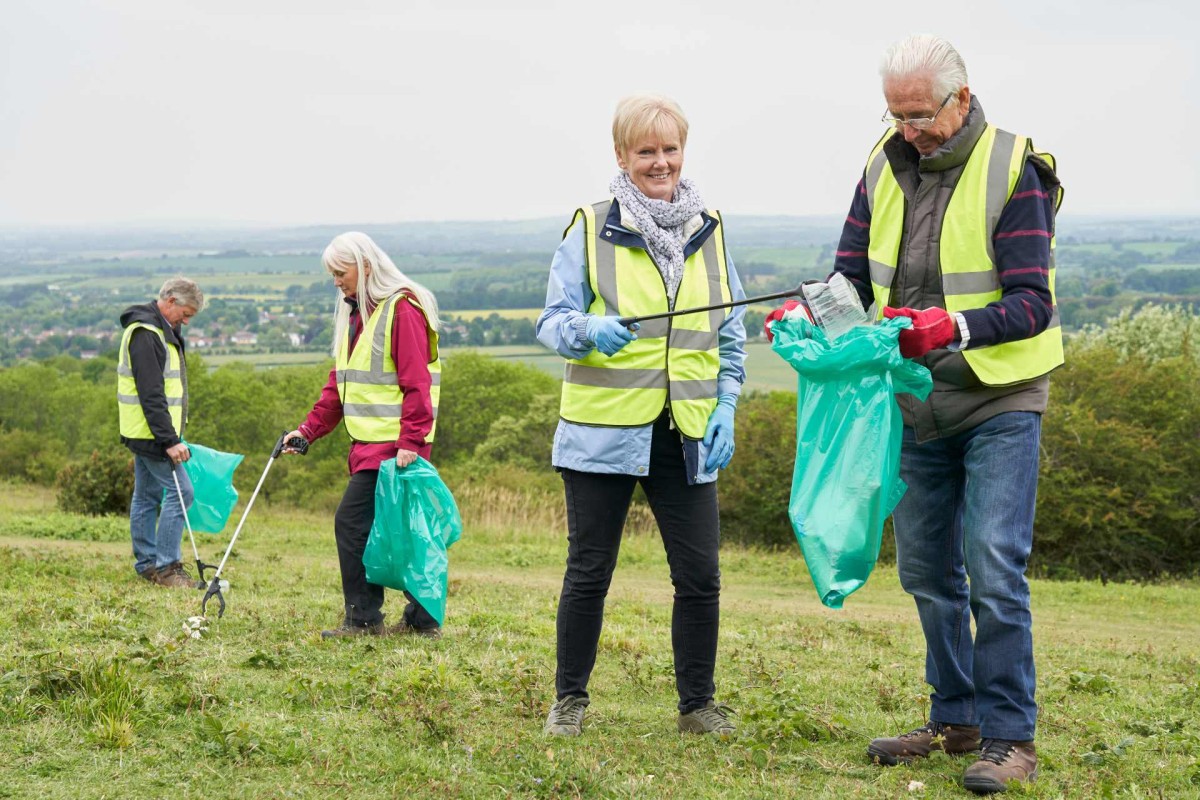 Group of volunteers picking up litter in the countryside