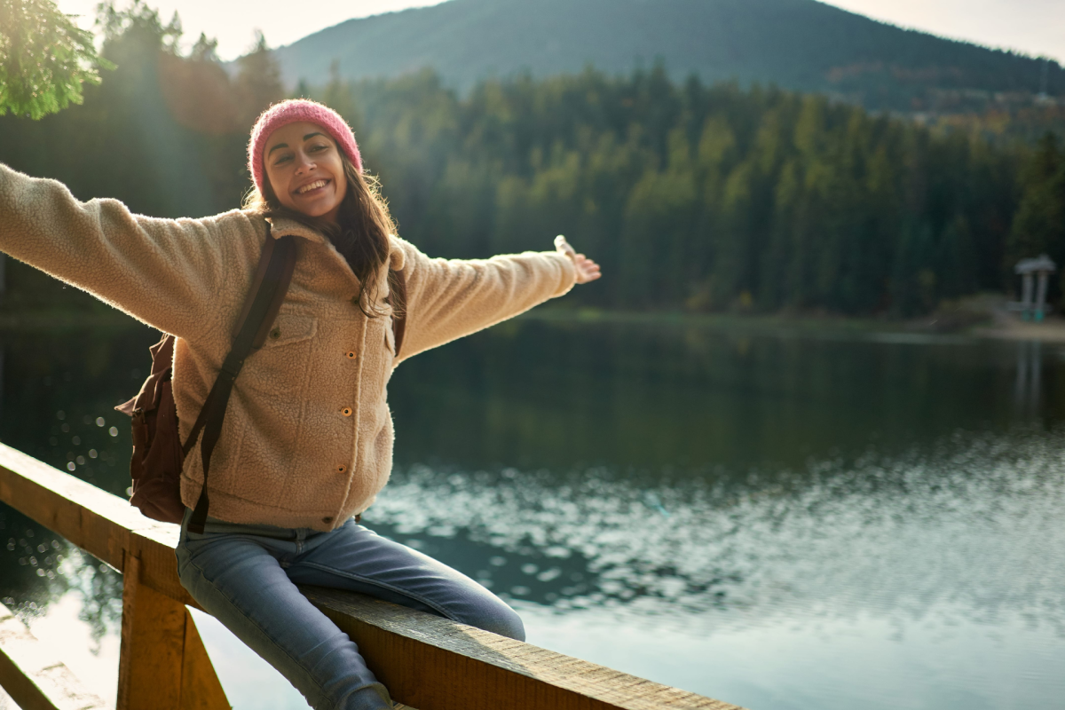 A woman sitting on a wooden bridge posing for a picture