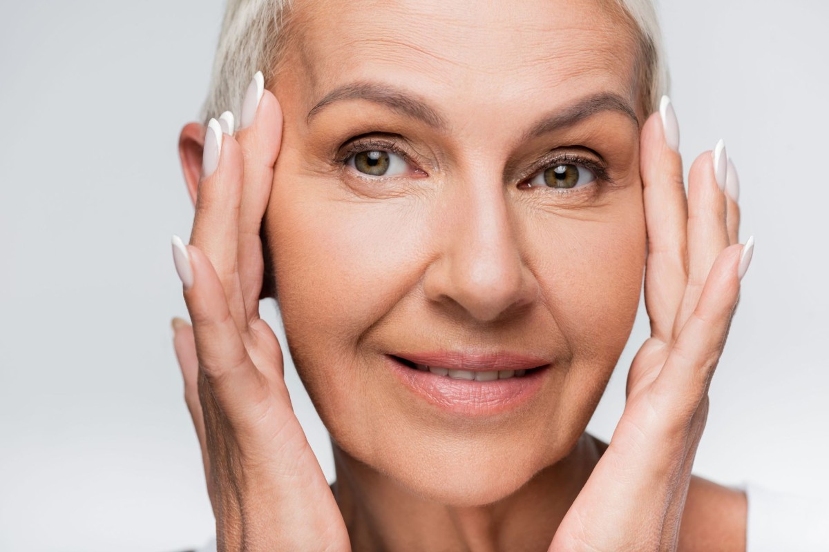 A closeup photo of a woman posing beautifully while holding her face